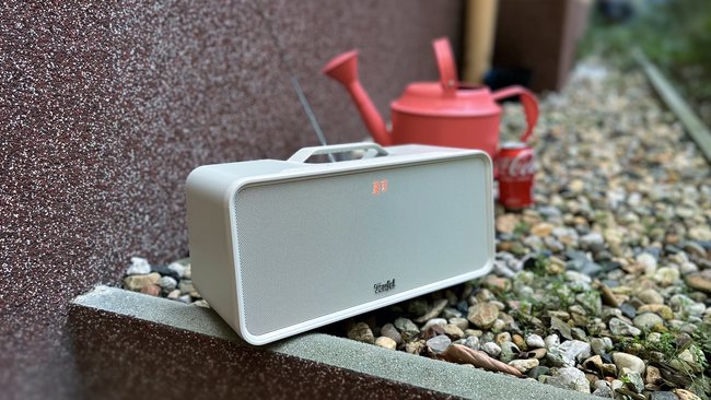 Bluetooth-Lautsprecher Teufel Boomster im Garten. Im Hintergrund eine rote Giesskanne und eine Dose Cola (Bildquelle: GIGA). Bluetooth-Lautsprecher Teufel Boomster im Garten. Im Hintergrund eine rote Giesskanne und eine Dose Cola (Bildquelle: GIGA).